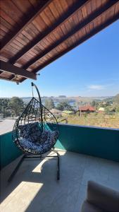 a swing on a balcony with a view of the ocean at Estadia Barragem do Salto - Casa Mugam in São Francisco de Paula