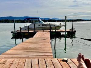 een persoon die op een steiger naast een boot ligt bij Suite on the Bay in Marsh Lake