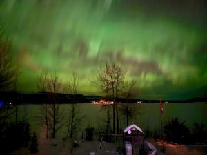een noorderlicht in de lucht boven een lichaam van water bij Suite on the Bay in Marsh Lake +14 foto's
