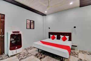 - une chambre avec un lit doté d'oreillers rouges et d'un radiateur dans l'établissement Hotel O The Village Resort, à Itwāri