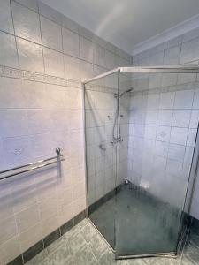 a shower with a glass door in a bathroom at Spacious Queen Room in Comfortable Two Story House - L2 