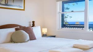 a bedroom with a bed with a view of the ocean at Flipside Apartment in Kiama