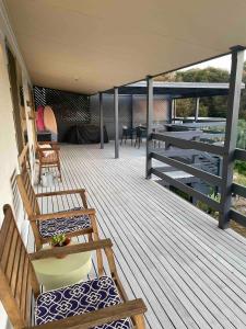 a deck with benches and chairs on a house at Southside at Vivonne in Vivonne Bay