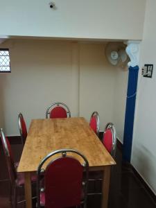 a conference room with a wooden table and red chairs at Home away from home in Palakkad in Palakkad