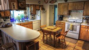 a kitchen with wooden cabinets and a white stove top oven at Bluebird Hill and Star Suite home in Rio Frio