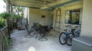 a patio with a table and chairs and a bike at Bluebird Hill and Star Suite home in Rio Frio