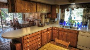 a kitchen with wooden cabinets and a table and chairs at Bluebird Hill and Star Suite home in Rio Frio +65 photos