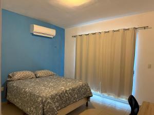 a bedroom with a bed and a window at Pez Vela in Puerto Morelos