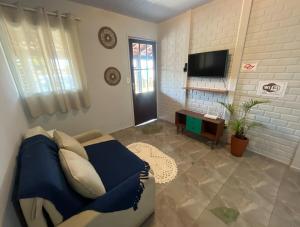 a living room with a bed and a flat screen tv at Inn Nature Pousada Casa de Veraneio com piscina in Palhoça