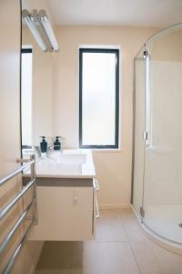 a white bathroom with a sink and a window at Cardrona Alpine Villa in Cardrona +23 photos