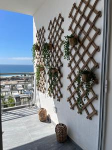 a wall with plants on it with a view of the ocean at Rosarito Sol y Mar Getaway in Rosarito Beach