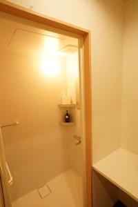 a bathroom with a shower with a light on the door at Yasuragi-KAWAGOE 1F in Kawagoe