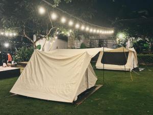 Plei ChuêtXom Camping的两个帐篷在晚上在院子里