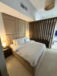 une chambre avec un grand lit avec des draps blancs dans l'établissement F1 - Ivy Studio Golf View Ansam Yas Island, Theme Parks, à Abu Dhabi 17 autres photos