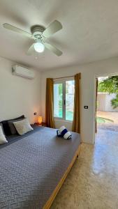 a bedroom with a bed with a ceiling fan at Casa Luma Hostel Boutique in Tulum