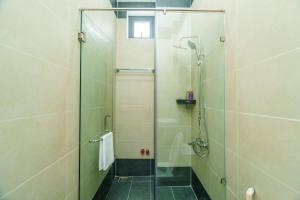 une douche avec une porte vitrée dans une salle de bain dans l'établissement HomyPlus Apartment, à Hô-Chi-Minh-Ville