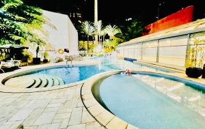 ein Pool neben einem Gebäude in der Unterkunft Suite RDS Vila Olimpia in São Paulo