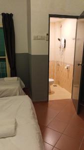a bedroom with a bed and a bathroom with a shower at Heeren Inn at Jonker Walk in Melaka