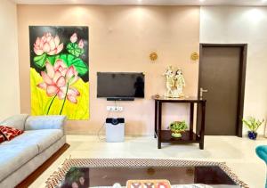 Una sala de estar con un sofá y un televisor. en Marwar Essence, en Jodhpur