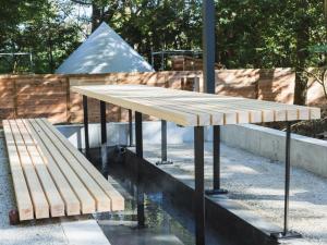 a table and a bench next to a fence at TIMeSCAPE -hakone- in Miyanoshita