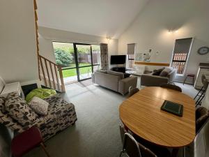 a living room with a table and a couch at 15b Caverhill Close in Hanmer Springs