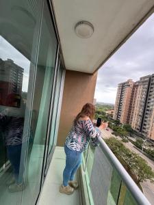 a woman taking a picture on the balcony of a building at Apartamento amoblado en el norte de barranquilla in Barranquilla