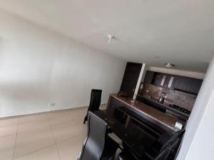 a kitchen with black chairs in a white room at Apartamento amoblado en el norte de barranquilla in Barranquilla