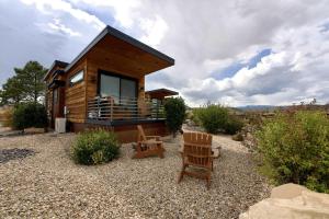 a log cabin with a bench and a chair at Escalante Escapes Fox Tail- Loft Escape in Escalante
