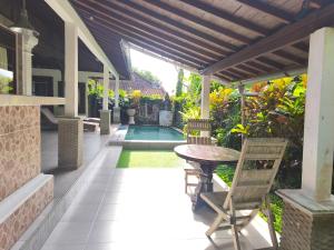 a patio with a table and chairs next to a pool at Cozy two bed room with swiming pool in Ubud