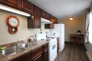 a kitchen with a sink and a clock on the wall at St Andrews Inn & Suites in Saint Andrews