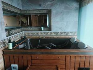 Un baño con bañera y un espejo grande. en Shangri-la Zhaxidele Hotel, en Shangri-La