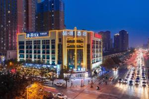 a lit up building in a city at night at James Joyce Coffetel Xi'an Laochenggen Hongmiaopo Metro Station in Xi'an