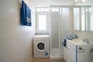 a bathroom with a washing machine and a sink at Apartment Sant Antoni de Calonge in Sant Antoni de Calonge
