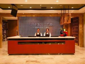 two people sitting at a bar in a restaurant at James Joyce Coffetel·Changchun Railway Station in Changchun