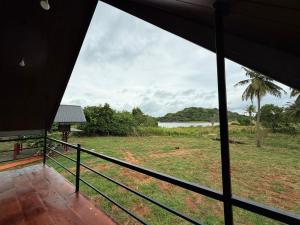 a view of a field from the porch of a house at Kolla Watersong Resort in Sigiriya