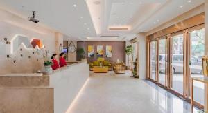 a lobby with two people sitting at a waiting room at Borrman Hotel Huizhou West Lake Shuidong Street in Huizhou