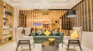 a living room with a green couch and chairs at City Comfort Inn Kunshan Development Zone Penglang Xinxing Middle Road in Suzhou