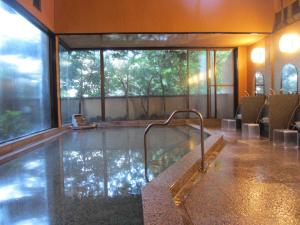 a jacuzzi tub in a building with a large window at Senkei in Hakone