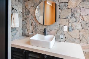 a bathroom with a sink and a stone wall at Family Apartment Steps from the Beach in Bucerías