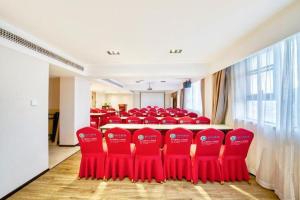 a group of red chairs in a conference room at City Comfort Inn Kunshan High-speed Railway Station Renmin Road in Suzhou