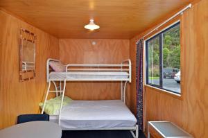 una casa pequeña con 2 literas en Leith Valley Holiday Park and Motels, en Dunedin