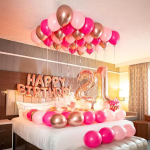 a bed with pink and gold balloons and a happy birthday sign at Majestic Residence KL in Kuala Lumpur