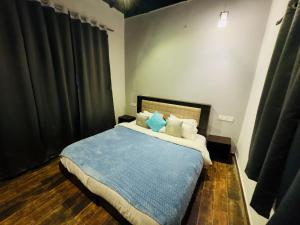 a bedroom with a bed with blue sheets and pillows at Villa Exotica, Igatpuri in Ghoti Budrukh