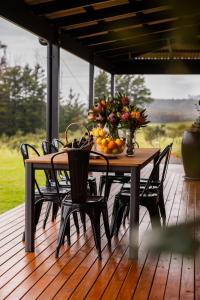 una mesa de madera con un bol de fruta en la terraza en The Olive Leaf Retreat, en Latrobe