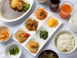 a table with plates of food and bowls of food at APA Hotel Chibachuo Ekimae in Chiba
