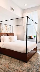 a bedroom with a canopy bed with white sheets at Downtown 3B2B Apt with full kitchen, Sleeps 6,Near PPAC & Dining in Providence