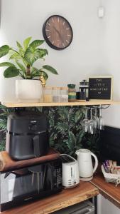a clock on a wall above a kitchen counter at The Little Homestead in Gqeberha
