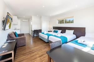 a hotel room with two beds and a couch at Chinchilla Tourist Park in Chinchilla +61 photos