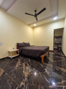 a bedroom with a bed and a ceiling fan at Svayambhu Stay in Bhogwe