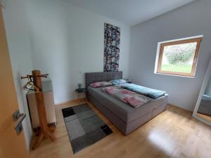 a small bedroom with a bed and a window at In den Bergen in Übersaxen